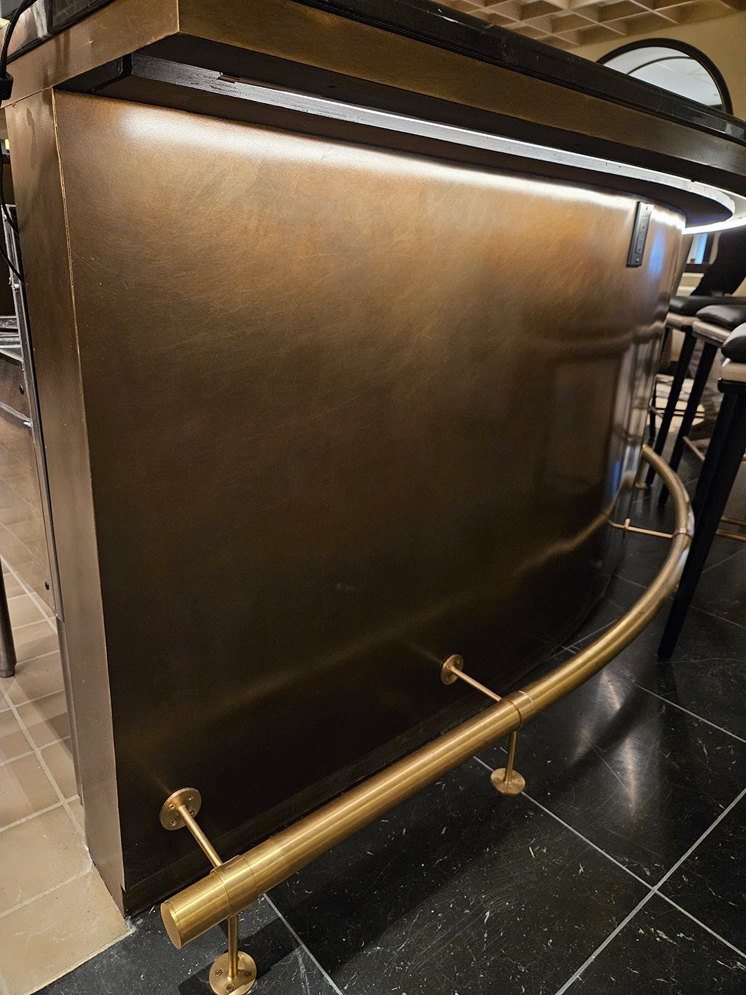 Lobby bar — custom patina brass bar front and satin brass foot rail