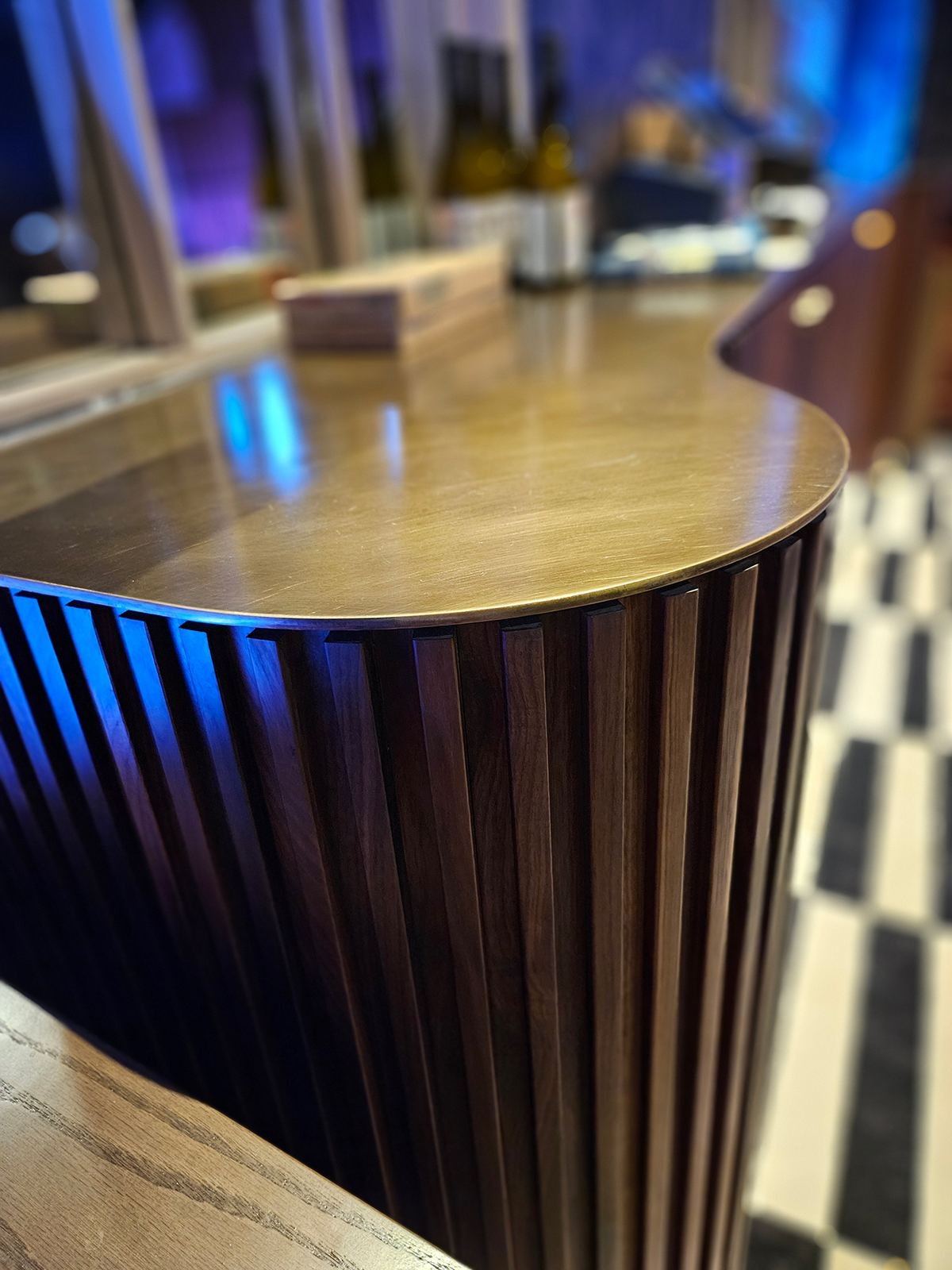 Music lounge — curved walnut stage beneath ribbed wood archway
