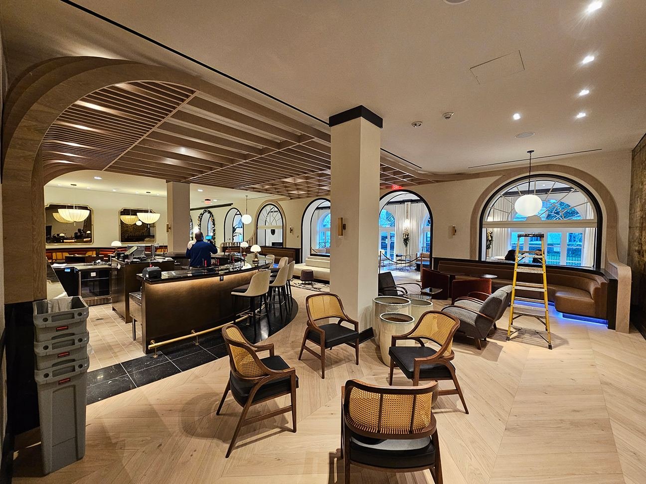 Lobby bar — curved brass bar front with baffle ceiling overhead
