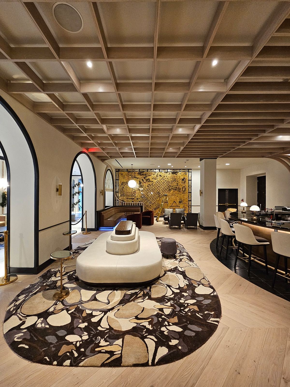 Lobby — coffered white oak ceiling, arched openings and curved bar