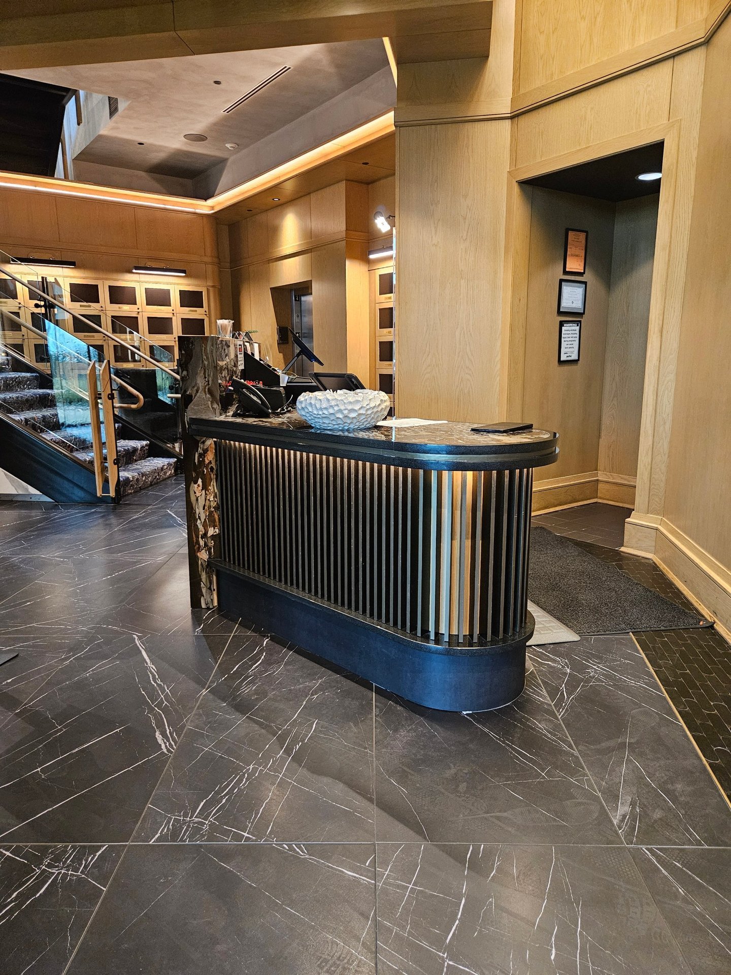 Ruth's Chris entry host desk with millwork screen and marble stairs